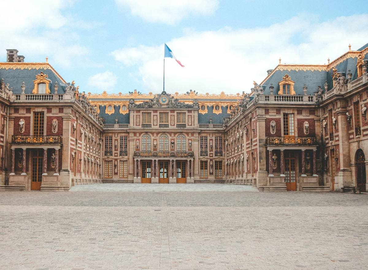 Cour de marbre du château de Versailles, façades de brique et de pierre, drapeau français