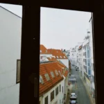 Rue de ville vue à travers une grande fenêtre, immeubles et voitures garées